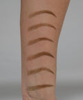 Set of eyebrow pencils on a person's arm against a neutral background