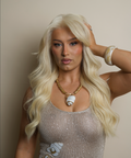 Woman with long blonde hair wearing a sparkly top against a neutral background