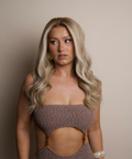 Woman wearing a brown strapless top against a beige background