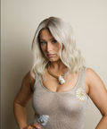 Woman wearing a sparkly top with decorative elements against a plain background