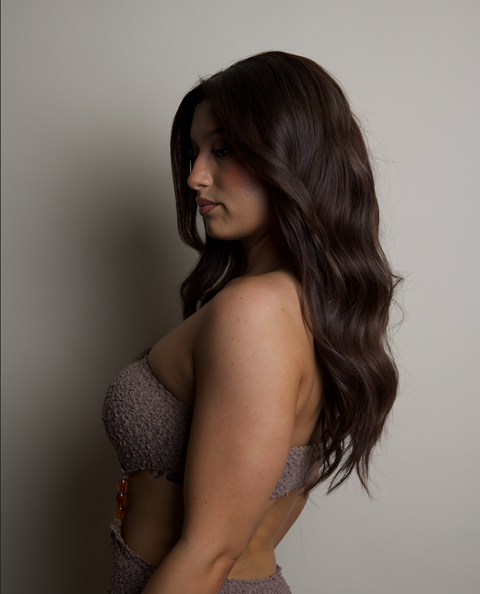 Woman wearing a patterned dress against a plain background